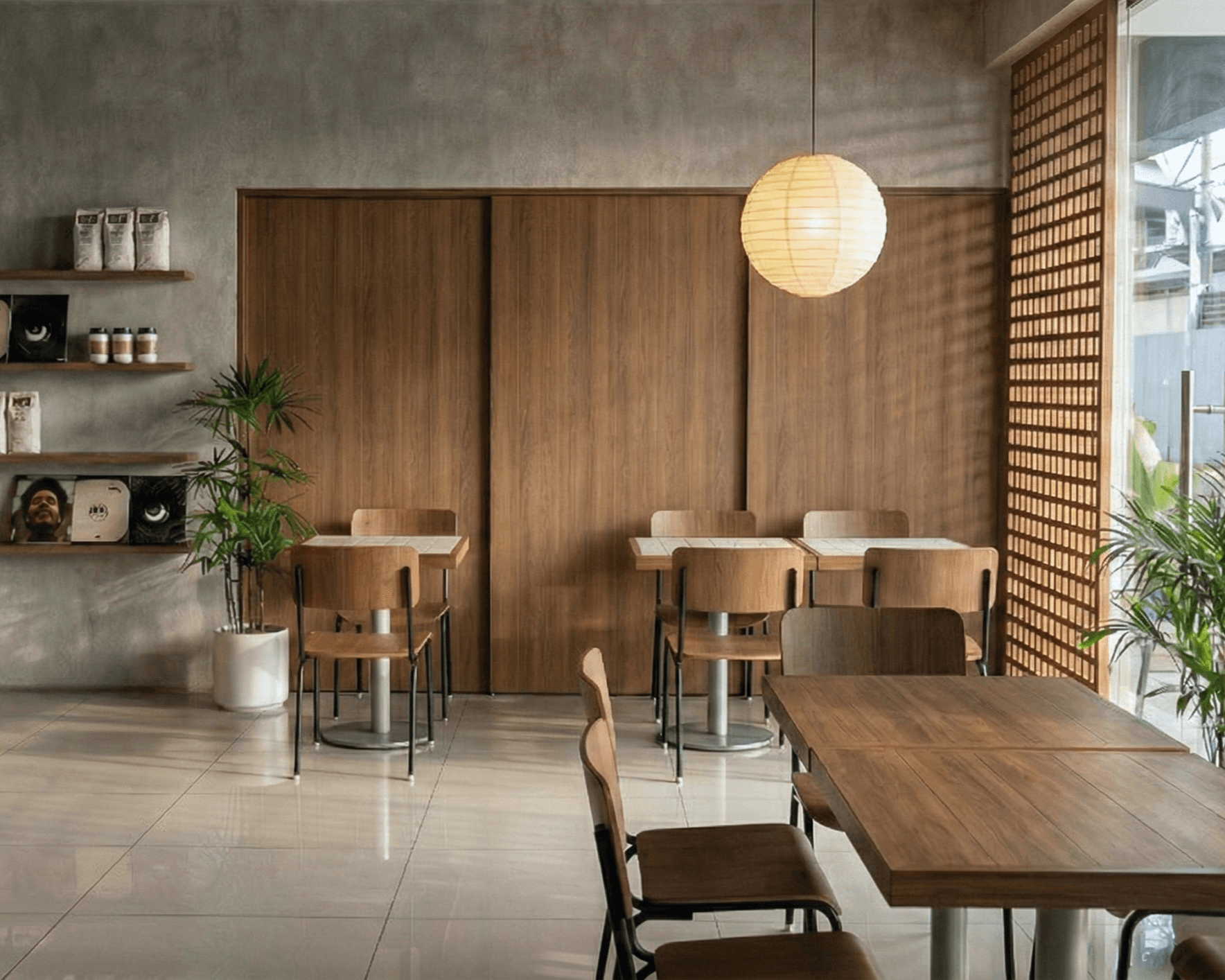 Dining room with a paper lantern, tall timber doors and open shelving.