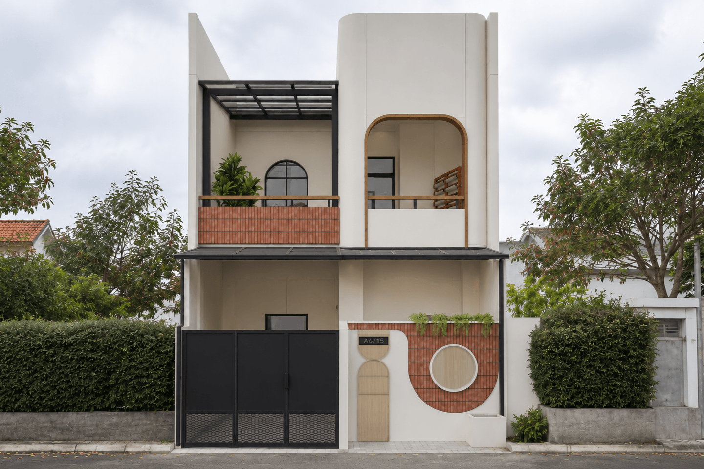 The renovated facade: a white rounded volume, a brick-faced balcony under a black pergola, and a circular brick motif by the door.