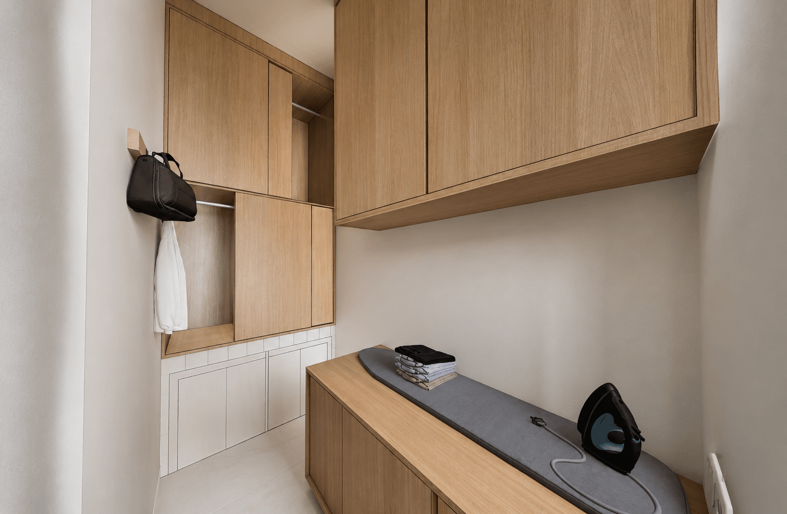 Utility wall with a fitted ironing counter and wall cabinets.