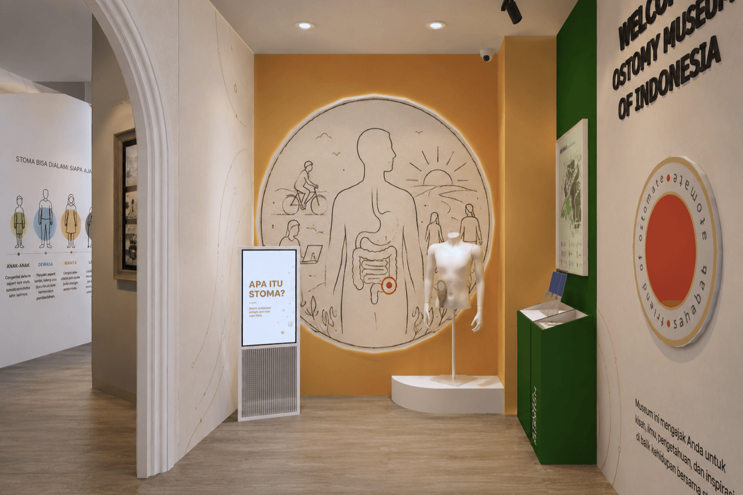 Entrance gallery: an arched opening onto an orange wall with a line drawing of the body, a mannequin and an information kiosk.