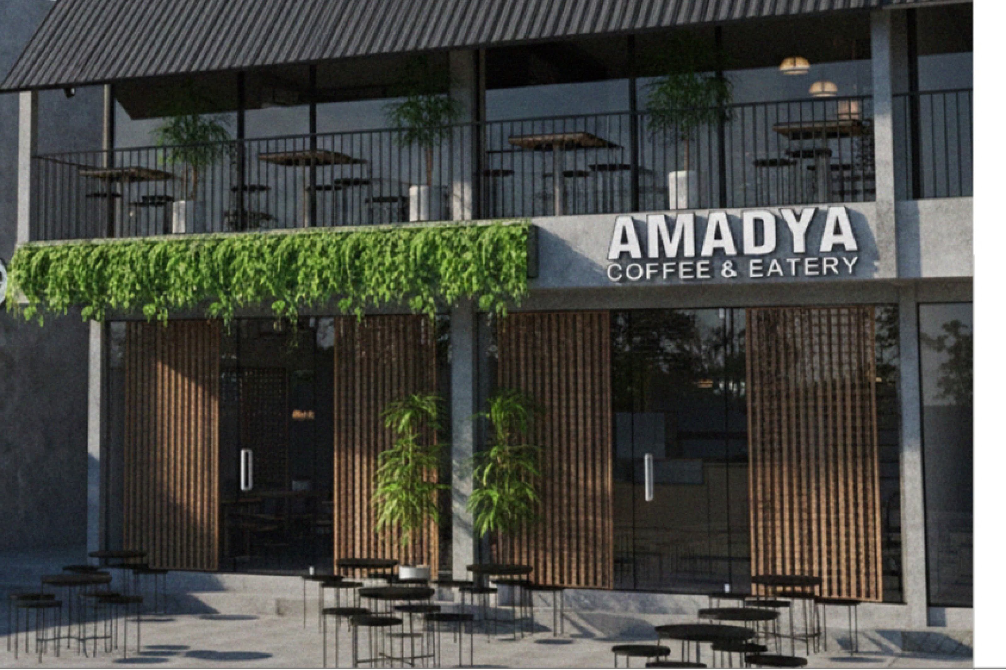 Amadya storefront with a dark corrugated roof, hanging greenery along the fascia and an open terrace below.