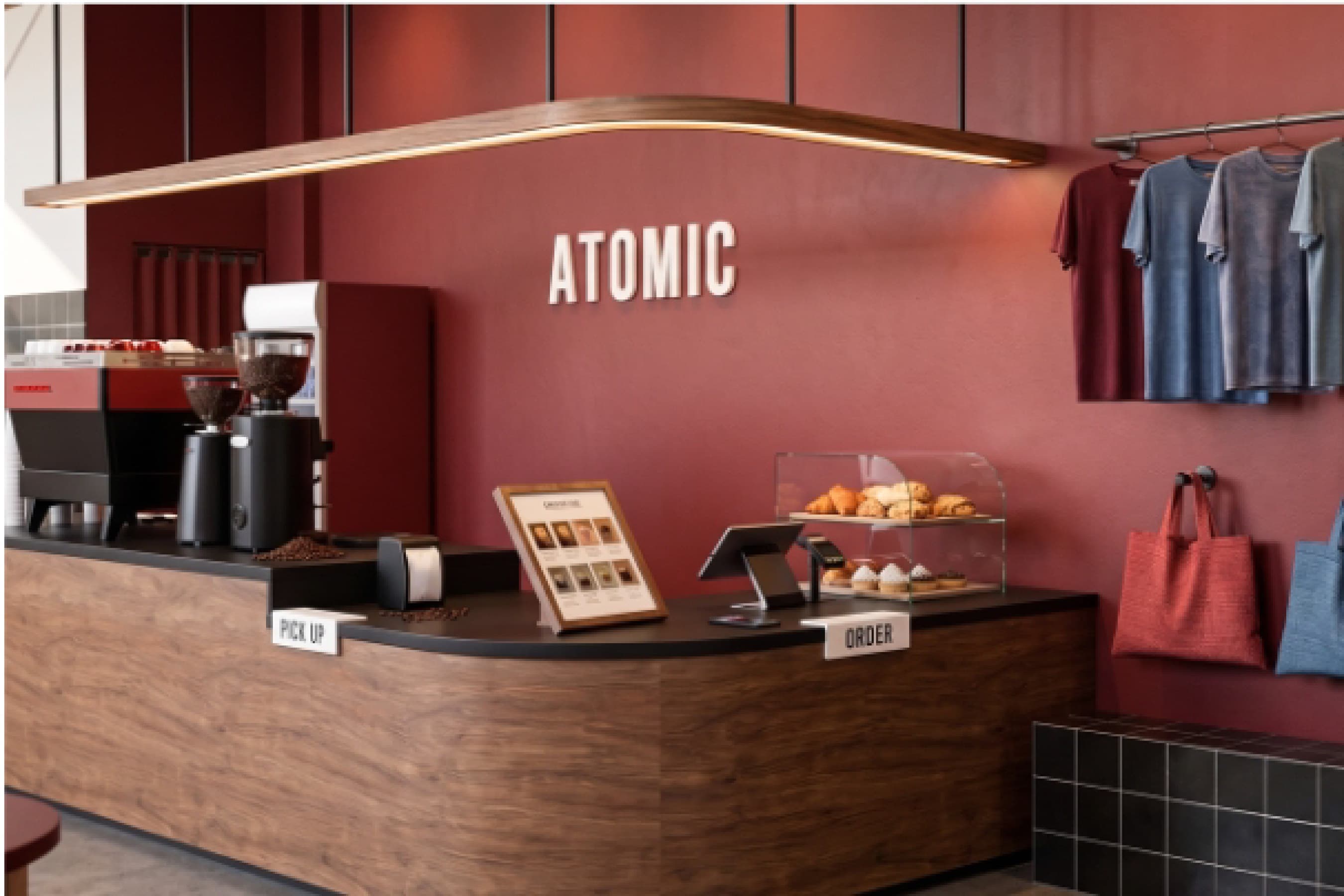 Closer view of the red counter wall with the Atomic wordmark and merchandise on display.