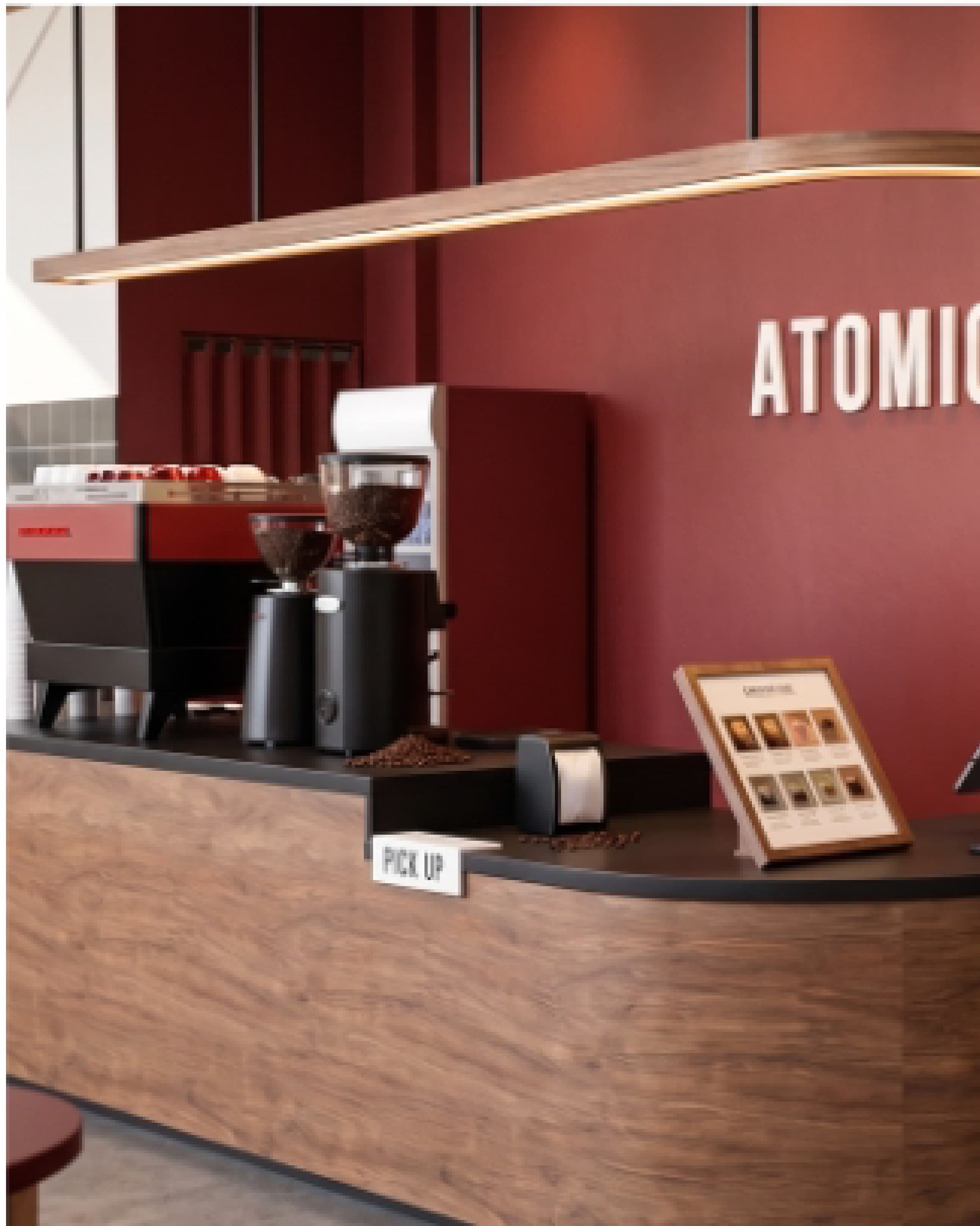 Closer view of the red counter wall with the Atomic wordmark and merchandise on display.