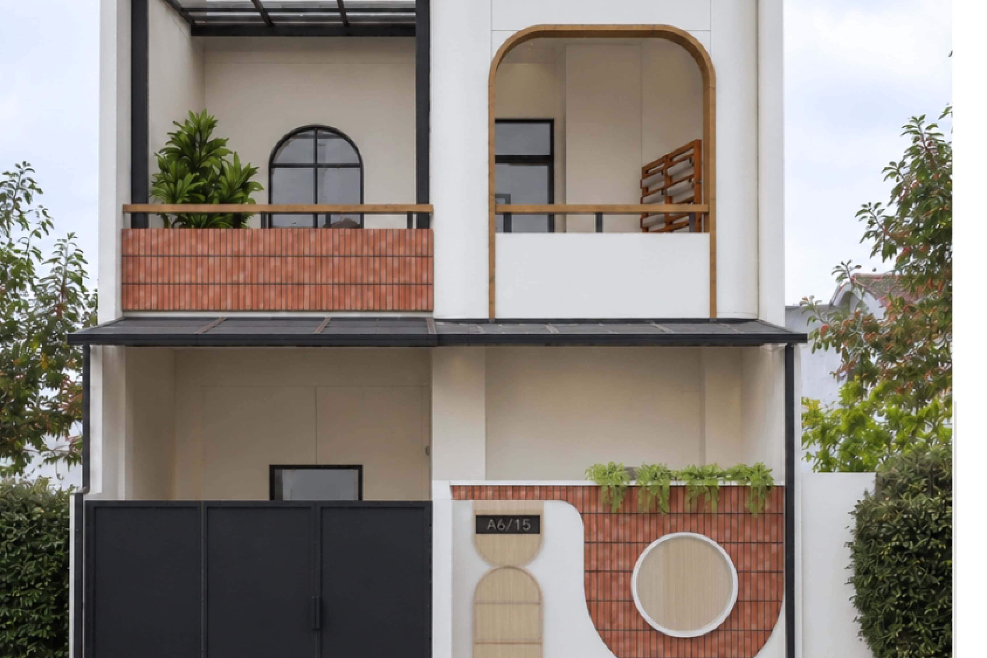 House exterior with red brick arches, a first-floor balcony and greenery along the facade.