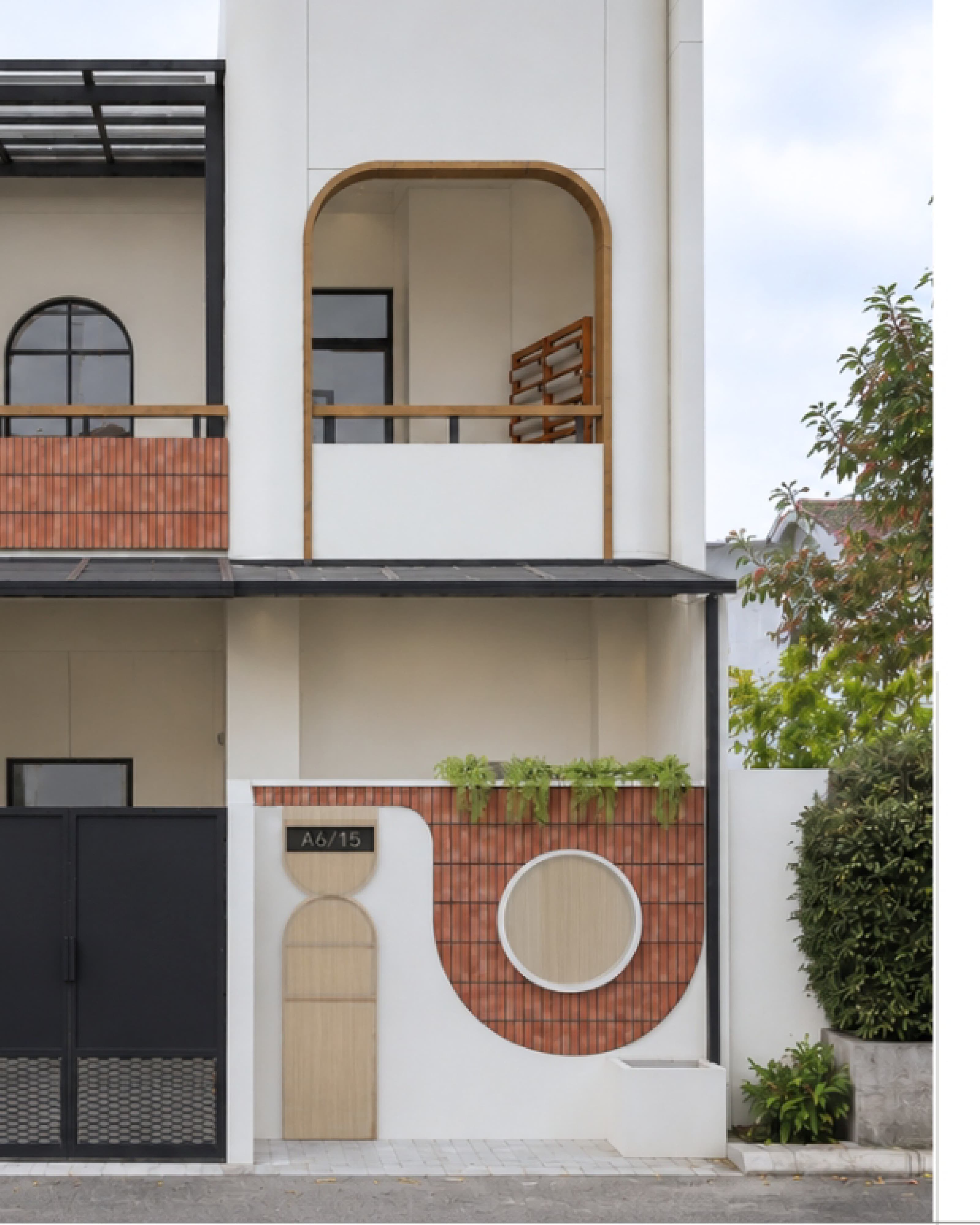 House exterior with red brick arches, a first-floor balcony and greenery along the facade.