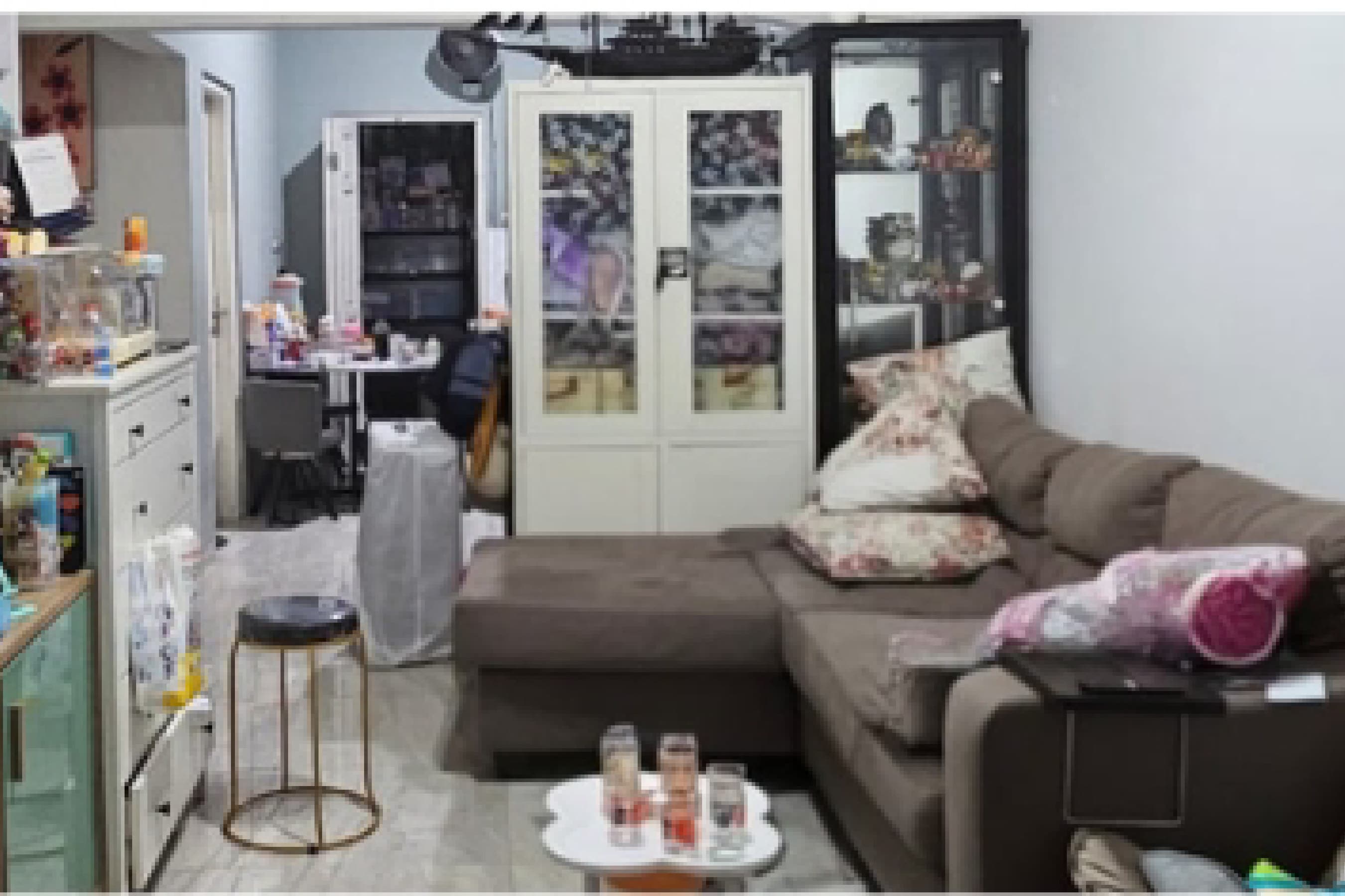 Site documentation of the existing living room before renovation, with a sectional sofa and display cabinet.